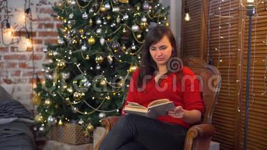 在圣诞树附近看书的年轻女子